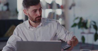 Çağdaş bir ofis ortamında dizüstü bilgisayarla uğraşan odaklanmış bir profesyonel..
