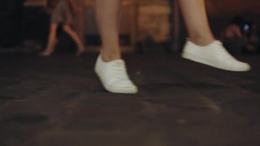 . Kamera, şehirde ağır çekimde dans eden bir kadının ayaklarını takip ediyor. Beyaz spor ayakkabılarla, gece yarısı açık ayakkabıyla. Sokaklar, işe gidip gelen bir kızın moda yolculuğuyla dolu.