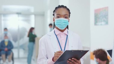 Profesyonel devlet hastanesinde çalışan Afrikalı Amerikalı doktor kadın koruyucu maske takıyor. Kadın portresi. Sağlık çalışanı. Sağlık ve salgın hastalıklar.