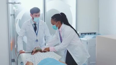 Sağlık uzmanları bugün modern bir sağlık ortamında erkek bir hastaya tıbbi tedavi uyguluyorlar.