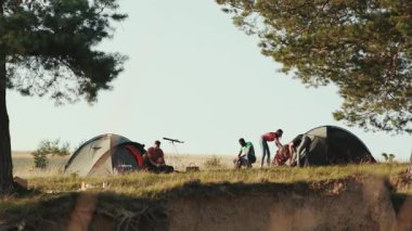 Genç bir arkadaş grubu açık havada güneş ışığında kamp kuruyor. Parti zamanı, arkadaşlık, eğlence. Takılıyoruz, dinleniyoruz, dinleniyoruz. Pozitif duygular.