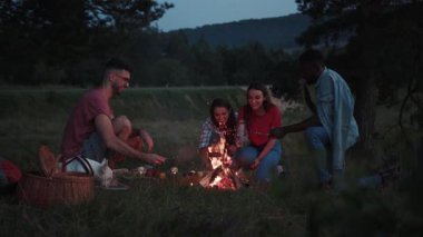 Kamp ateşinin yanında kamp ateşine yakın bir grup insan kamp ateşi oyunları oynuyor ve kamp ateşi ızgarası yiyor, ateşin yanında odunla kamp ateşi hikayeleri anlatıyor, doğada geceleri alevler var. Fransız bulldog