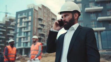 Yakışıklı sakallı, endişeli iş adamı telefonda konuşuyor, iç çekiyor, sinirleniyor, aramayı bitiriyor, telefonu cebine koyuyor. Tartışma, çatışma. Erkek portresi