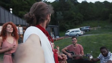 Çok ırklı arkadaşlar birlikte selfie çekiyorlar. Kameraya bakıp gülümsüyorlar. Mutlu konuşuyorlar. Yaz yemeği için bira içiyorlar.