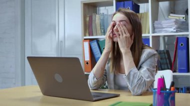 Çekici genç bayan yönetici, ofiste bilgisayarla çalışmaktan, yüz masajı yapmaktan, iş yerinde motivasyon eksikliği hissetmekten bıktı. İş adamları. Sıkıcı iş.