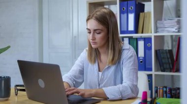 Şirketimizdeki ofis bilgisayarında çalışan güzel ve zeki bir kadın. Modern çalışma ortamında klavyeye dizüstü bilgisayar kullanan genç bir kadının portresi.