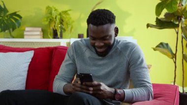Neşeli, çekici, melez, akıllı telefon kullanan, zaferi kutlayan, evdeki kırmızı kanepede dinlenen, mali açıdan başarılı bir yarışçı. Mutluluk ve servet kavramı.
