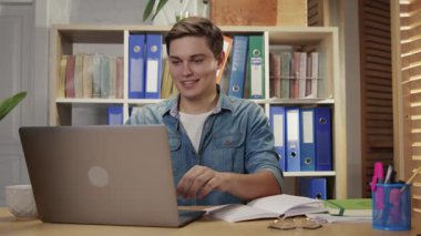 Modern ofiste dizüstü bilgisayarda çalışan neşeli bir çalışan. Hırslı genç iş adamı şirketin çalışma alanındaki mali başarısıyla seviniyor..
