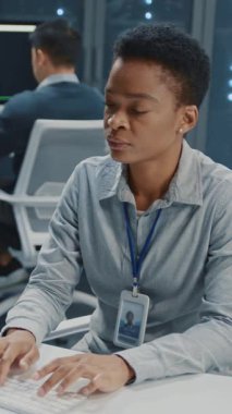 Afrika kökenli Amerikalı genç bayan bilişim idarecisi ofiste işbirliği yapıyor. Veri merkezinde çalışan çok ırklı profesyonel ekip ve bulut hesaplaması.