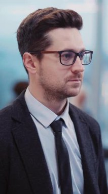 Takım elbiseli ve kravatlı şık bir adam hareketli bir şehirde rahatça dolaşır ve sofistike bir görüntü sergiler. Şık göz giysisi karizma katıyor.