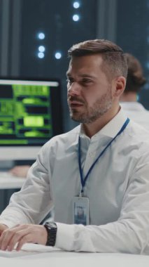 Gelecekteki ofis. Bilgisayarda sakallı bilişim yöneticiliği programı. Veri Merkezi personeli dijital sunucu odasında robot sayborg çalışanıyla işbirliği yapıyor. Yapay zekayla insan etkileşimi.