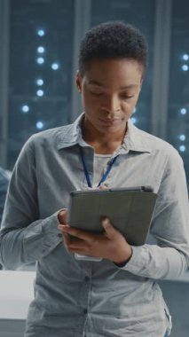 jportre afrikalı amerikan bayan çalışan bilişim yöneticisi süper bilgisayar sunucu odasında işbirliği yapıyor. Bilgi İşlem. Profesyonel personel. Veri merkezi.