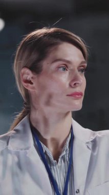 Videoda kendine güvenen beyaz önlüklü bir kadın var. Uzmanlığı simgeliyor. Çekici ifadeleri otorite ve bilgi taşıyor.