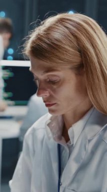 Yazılım geliştiricisi sunucuları izleyen güzel bir kadın bilişim destek uzmanı yüksek teknoloji laboratuvar ofisinde birden fazla bilgisayar kullanıyor. Bulut hesaplama. Veritabanı.