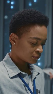 Genç akıllı bilişim kadın uzmanı veri merkezi deposunda çalışan yazılım sunucusu verilerini kontrol ediyor. Telekomünikasyon. Teknoloji.