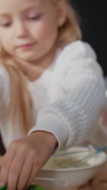 Çekici kız kesimi yeşil salata ve mutfak tezgahında yemek pişirmek için çırpılmış tavuk yumurtası ekliyor. Kahvaltılık omlet. Yavaş çekim