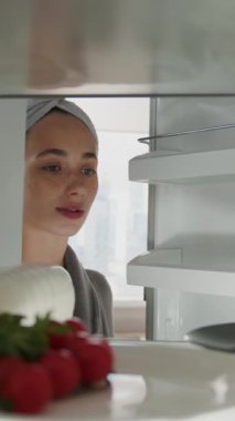 Portre genç bayan buzdolabının kapağını açar içine bakar yiyecek alır ve kapatır. Buzdolabı, öğle yemeği, hazırlık. Kapatın. Yavaş çekim