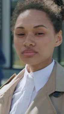 Çekici, melez bir kadının yüzüne bak. İş merkezinin yakınındaki kendine güvenen kameraya bak. Çok ciddiyim. İnsanlar etrafta dolaşıyor. Gün ışığında dışarıda. Yavaş çekim