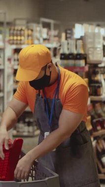 Süpermarkette Asyalı işçi sabah vardiyasında çalışan taze meyve sebzelerini raflara diziyor. Market çalışanı. Mesleğiniz? Çalışma alanındaki insanlar. Bakkaliye..