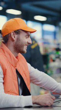 Kafkasyalı genç bir kasiyer süpermarkette müşteriyle iletişim kuruyor. Güzel bir kadın dostça hizmetlerden zevk alıyor..