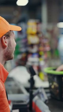 Kafkasyalı genç kasiyer organik gıda ürünlerini tarayıp marketteki kadın müşteriye servis yapıyor. Pazar yeri. Ticaret konsepti.