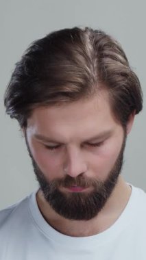 Beyaz tişört giyen beyaz sakallı adamın gri reklam arka planına gülümseyen beyaz adamın stüdyo portresi..