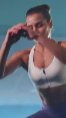 Genç aktif, güzel sporcu kadın profesyonel modern spor salonunda yoğun egzersizler yaparken terliyor. Sağlık, vücut geliştirme, aktivite kavramı.