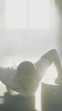 Afro-Amerikan güçlü konsantre adam ağırlık çalışırken halter disklerinde şınav çekiyor. Spor salonu konsepti. Vücut geliştirme uzmanı.