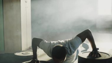 Afro-Amerikalı yakışıklı, güçlü vücut geliştirme sporcusu spor salonları kullanıyor halter disklerinde şınav çekiyor ve spor yapıyor. Atletik yaşam tarzı. Etkin sporlar.