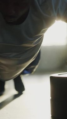 Siyah sağlıklı genç sporcu ağırlık odasında vücut geliştirme egzersizi yapıyor. Afro-Amerikalı atlet şınav çekiyor. Güneş ışığı. Modern spor salonu.