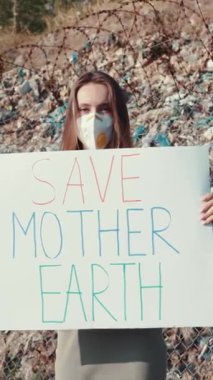 Tutkulu ve kendini adamış bir eylemci, çevre koruma bilincini artırmak için büyük bir işaret tutuyor.