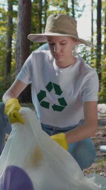 Sadık bir gönüllü doğada çöp toplar, çevresel farkındalığı ve geri dönüşüm çabalarını teşvik eder