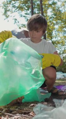 Çevresel farkındalık ve sürdürülebilirliği teşvik eden, mahalle temizliğine katılan küçük bir çocuk