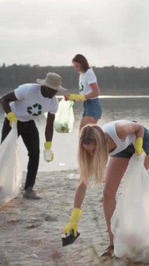 Gönüllüler, çevresel sürdürülebilirliğin önemini desteklemek amacıyla kıyı şeridinden çöp topluyorlar.