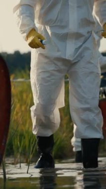 Koruyucu teçhizat kullanan bir araştırmacı, sulak sularda ilerler. İç görü için ekosistemi yakından inceler.