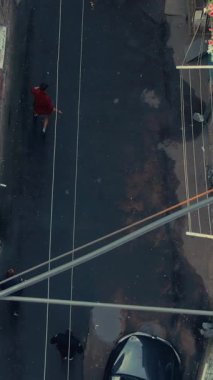 Etkileyici bir yukarıdan çekim canlı yaya geçidi ve park edilmiş arabalarla dolu hareketli bir şehir caddesini gösteriyor.