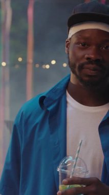 Neşeli bir partide neşeli ve rahat bir atmosfer sunan bir adam ferahlatıcı bir içkinin keyfini çıkarıyor.