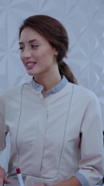 Profesyonel giyimli bir kadın, uzmanlığını ve yeterliliğini sergileyerek, düşünceli bir şekilde modern bir çevreye bağlanır.