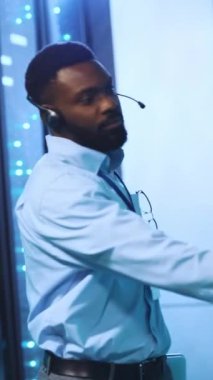 Odaklanmış ve kararlı bir birey, kulaklık takarken modern bir teknoloji çalışma alanında yol alıyor.