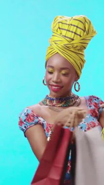 Şık bir kadın kendine güvenerek poz veriyor, bir dizi parlak renk ve göz alıcı aksesuar sergiliyor.