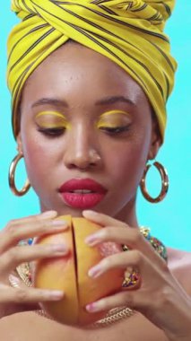 Son derece zarif bir kadın çeşitli turunçgil meyveleri tutuyor, parlak renkler ve kalın aksesuarlar sergiliyor.