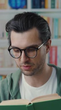 Yansıtıcı bir adam, kitaplarda sergilenen canlı edebiyatla rahatça çevrelenmiş bir şekilde okumaya dalmıştır.