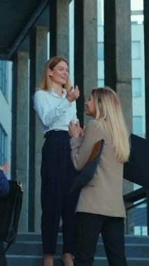 Bir ofis girişinde profesyonel kadınlar arasında dinamik ve çekici bir etkileşim vardır.