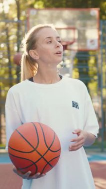 Kendini işine adamış ve odaklanmış bir bayan basketbolcu canlandırıcı antrenman seansını dışarıda yapmaktan keyif alıyor.