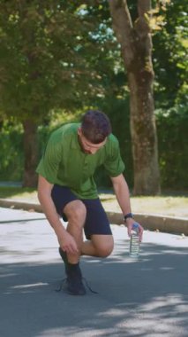 Atletik giysiler giyen bir adam, susuz kalmadığından emin olmak için dışarı çıkıp yürüyüş yapıyor.