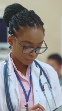 Yetenekli bir sağlık uzmanı titizlikle tıbbi bir ortamda bilgiyi inceliyor.