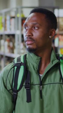 Yeşil ceket giyen odaklanmış bir birey, medya malzemelerini stoklama sürecinde aktif olarak meşgul