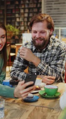 Neşeli bir kafede kahvesini yudumlarken hafif bir anın tadını çıkaran bir adam.