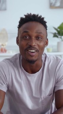 Neşeli bir genç adam pozitiflik saçan canlı ve modern bir ortamda büyük bir gülümsemeyle poz verir.