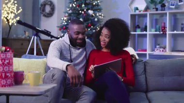 Birkaç öğrenci tablette video oyunu oynuyor. Kazanan kız. Erkek arkadaş sarılan kız. Kutlama atmosferi. Kapalı.